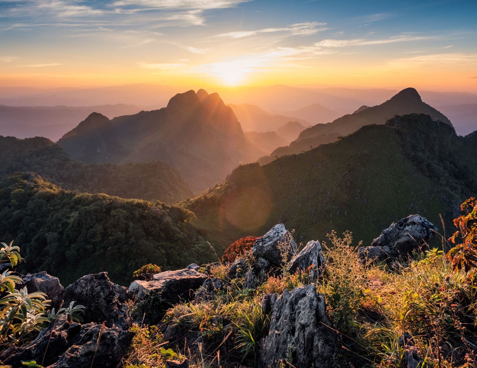 Sunrise light over layered mountains